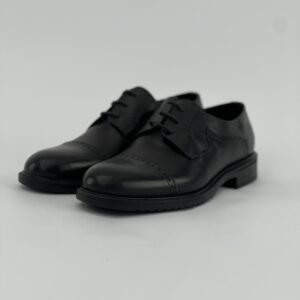 A black shoe with polka dots and laces