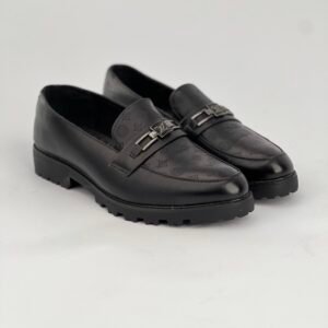 A black Vernee leather slip-on shoe with a silver buckle Shape LV 